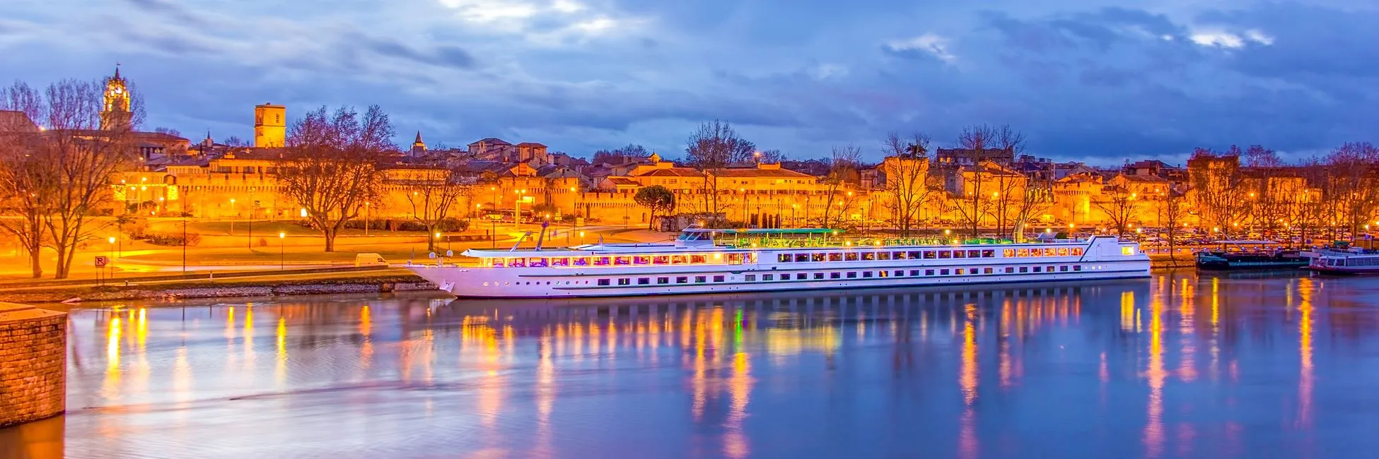 Bateau CroisiEurope traversant Avignon de nuit 