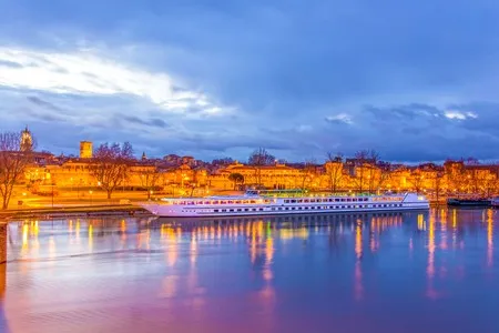 Bateau CroisiEurope traversant Avignon de nuit 