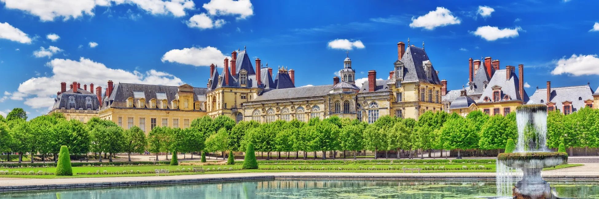 Vue ensoleillée sur le château de Fontainebleau et sa fontaine 