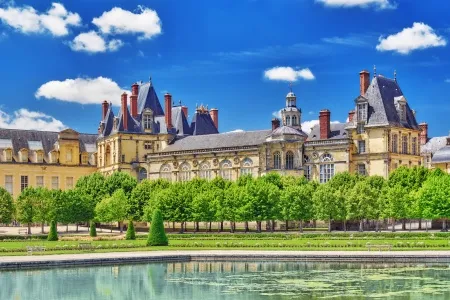 Vue ensoleillée sur le château de Fontainebleau et sa fontaine 